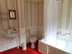 a bathroom with a toilet and a sink and a tub at Ferienwohnung Frohmut in Burg Stargard