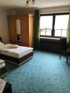 a bedroom with a bed and a desk and windows at Ferienwohnung Frohmut in Burg Stargard +8 photos