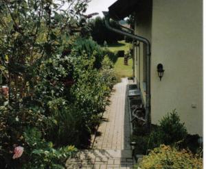 a garden with a brick walkway next to a building at großes Ferienhaus mit Terrasse am Granitzwald in Blieschow