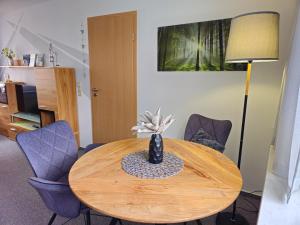 a wooden table with chairs and a vase on it at Ferienwohnung Martina in Hasselfelde +21 photos