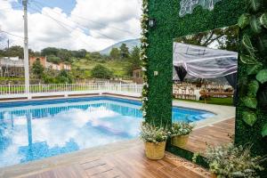 a swimming pool with a green wall next to it at Hotel Buenavista in Jocotitlán