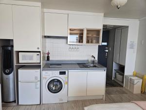 a kitchen with a washing machine and a washer at 에벤에셀 in Busan