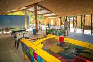 a play room with a pool table and tables at Camping Hourtin in Hourtin