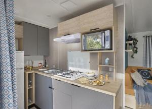 a kitchen with a sink and a stove top oven at Camping Hourtin in Hourtin