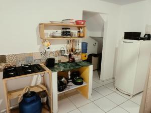 a small kitchen with a stove and a refrigerator at Casa da isy hospedagem in Natal