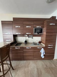 a kitchen with wooden cabinets and a sink at Cabacum Beach Residence in Varna City