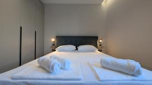 a white bed with towels on top of it at The Central Spot, Mostar in Mostar