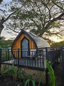 a small wooden dog house behind a fence at Rincón del Mar Glamping in Potrero