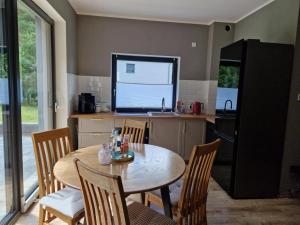 a kitchen with a table and chairs and a television at La Cassetta Verde in Lubkowo