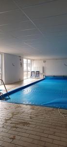 a large swimming pool with two chairs in a building at Ferienwohnung Ostseeglück in Schönhagen