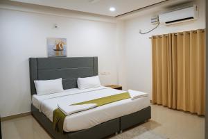 a bedroom with a large bed with a black headboard at White Fern Stays Serviced Apartments - Gachibowli in Hyderabad +122 photos