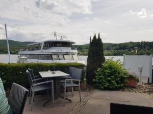 una mesa con sillas y un barco en el agua en Ferienhaus SonnenFänger, en Hemfurth-Edersee