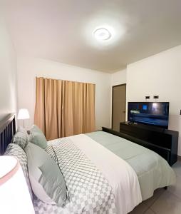 a bedroom with a large bed with a flat screen tv at Villa familiar en Punta Cana! Piscina Climatizada in Punta Cana