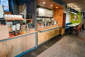a restaurant with a counter with dishes and a table at ibis budget Sète centre in Sète