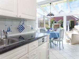 a kitchen with a sink and a dining table at Ferienwohnung Scheunemann in List +14 photos