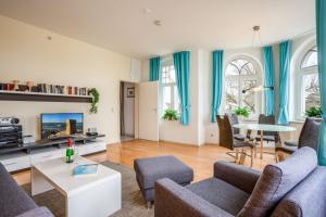 a living room with blue curtains and a couch and a table at Ferienwohnung 10 Haus Metropol in Binz