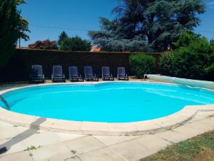 a large swimming pool with chairs in a yard at Maison Aunac in Aunac
