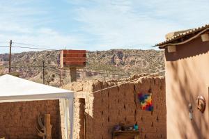 un bâtiment avec un mur avec une montagne en arrière-plan dans l'établissement Mestiza Hostal, à Humahuaca