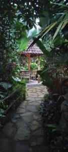 a stone walkway with a bench in a garden at Umah mimpi in Tampaksiring