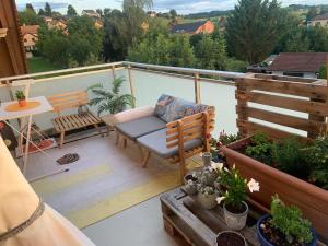a balcony with a chair and a table and some plants at Guesthouse ''Chatonnaye'' in Châtonnaye