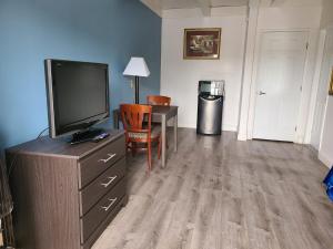 a living room with a tv and a desk and a table at All Seasons Lodge in South San Francisco