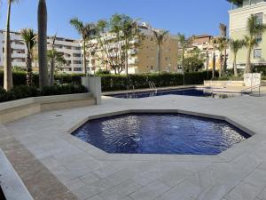 a swimming pool in a courtyard with trees and buildings at Terrasol Torre Del Mar Azucarera 4ª Planta in Torre del Mar