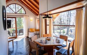 jadalnia ze stołem i krzesłami w salonie w obiekcie Paihuen Resort de Montaña w mieście San Martín de los Andes