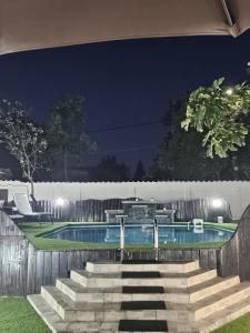 a swimming pool at night with stairs next to it at Home COLOSSEUM GUEST HOUSE in Bucharest