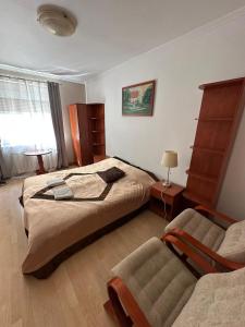 a bedroom with a large bed and a couch at Willa Rudno Nad Jeziorem in Rudno