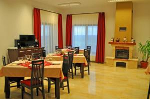 a dining room with tables and chairs and a fireplace at Pensiunea Cheile Apusenilor Cheile Turzii near Turda in Sănduleşti
