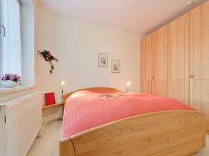 a bedroom with a bed with a red blanket at Ferienwohnung "Müritzblick" in Rechlin