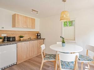 cocina con mesa blanca y sillas en Naturcampingplatz " Am Strand " Ostseebad Ückeritz, en Ückeritz