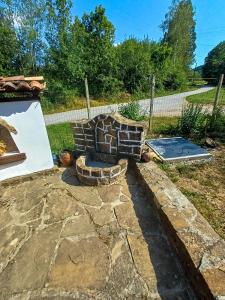 a stone patio with a fire pit in a yard at Vintage House in Elena +20 photos