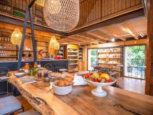 a kitchen with a large wooden table with a bowl of fruit at Camping Saint-Sozy in Saint-Sozy