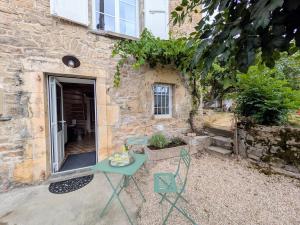 a table and chairs in front of a building at La Maison d'Emile in Sévérac d' Aveyron