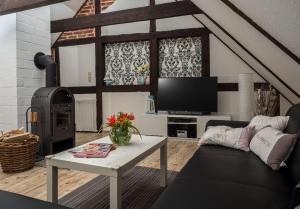 un salon avec un canapé et une table avec une télévision dans l'établissement Stilvolles Ferienhaus in der Altstadt, à Röbel 1 autre photo