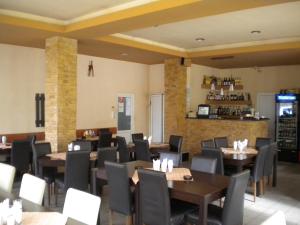 a restaurant with tables and chairs and a bar at Motel Dalia in Gilău
