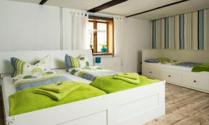 une chambre avec deux lits avec des draps verts dans l'établissement Stilvolles Ferienhaus in der Altstadt, à Röbel
