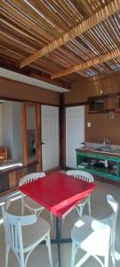 a red table and white chairs in a kitchen at Apartamento interior independiente in Coquimbo