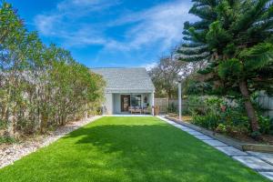 a yard with green grass and a house at Serenity by the Sea - Vilano Beach in Saint Augustine