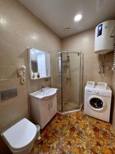 a bathroom with a toilet sink and a washing machine at Blue Horizon in Batumi +13 photos