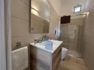 a bathroom with a sink and a toilet and a mirror at B&B Petrae House in Ostuni +32 photos
