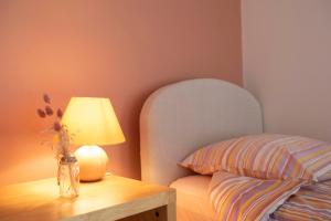 een lamp op een tafel naast een bed bij La Hulotte in Saint-Malon-sur-Mel