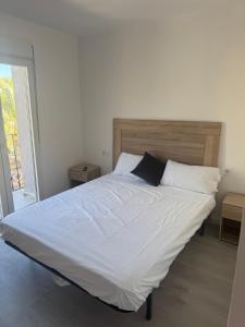 a bedroom with a large bed with white sheets and pillows at Nbm in Puerto de Gandía