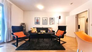 a living room with a couch and two chairs at Fewo 2 Stueven im Reetdachhaus Fewo cc in Kolpinsee