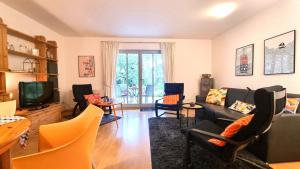 a living room with a couch and chairs and a tv at Fewo 2 Stueven im Reetdachhaus Fewo cc in Kolpinsee +12 photos
