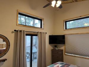 a bedroom with a bed and a tv and windows at The Bonnie View in Keystone
