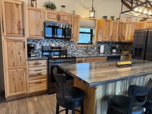a kitchen with wooden cabinets and a large island with bar stools at The Bonnie View in Keystone