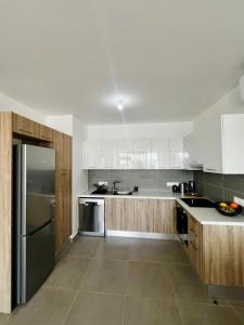 a kitchen with white cabinets and a stainless steel refrigerator at Modern Designer Home in Larnaka