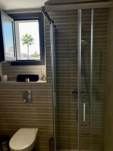 a bathroom with a shower with a toilet and a window at Modern Designer Home in Larnaka